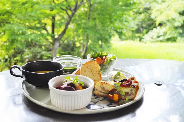 天気の日にはテラス席も。森の中のログハウスカフェで楽しむ世界の家庭料理